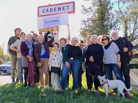 Membres du collectif réunis devant le panneau d'entrée de Cadenet