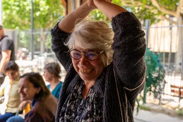 Une participante souriante, les bras levés, pendant un atelier