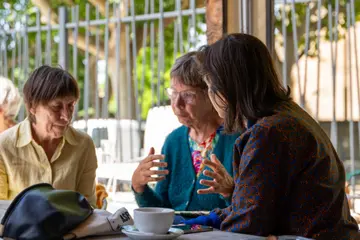 Discussion à trois en terrasse lors d'un atelier