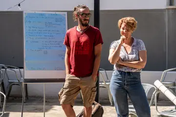 Deux animateurs devant un paperboard couvert de notes