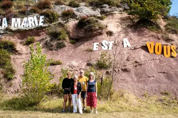 Membres du collectif devant l'inscription «&nbsp;La mairie est à vous&nbsp;» sur une colline