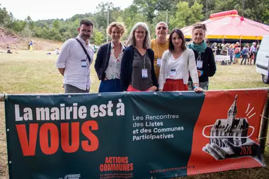 Des membres du collectif aux Rencontres des Listes et des Communes Participatives, devant la banderole «&nbsp;La mairie est à vous&nbsp;» d'Actions Communes